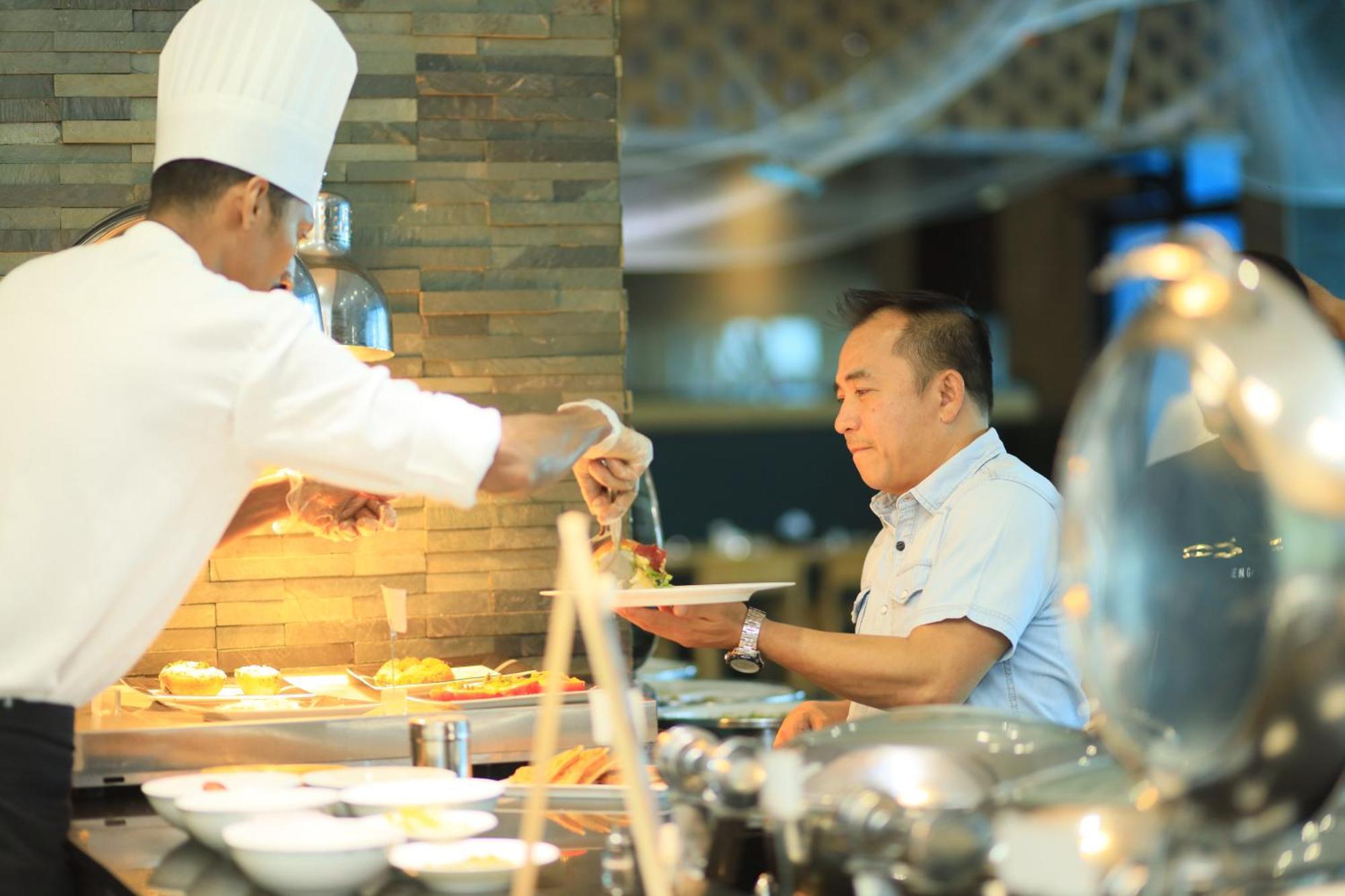 Ramee Grand Hotel And Spa Manama Exterior foto A chef serving food at a buffet